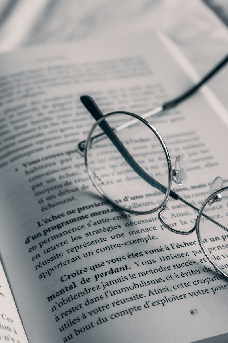 a pair of glasses sitting on top of an open book