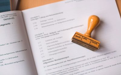 Photo by Markus Spiske A wooden rubber stamp resting on an open German legal document