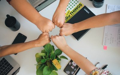 Photo by Antonio Janeski five fists bumping over office desk