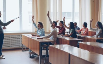 Photo by Vitaly Gariev Teacher pointing at students with raised hands