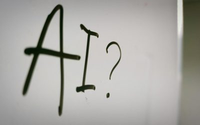 Photo by Nahrizul Kadri The letters AI and a question mark written in black marker on a whiteboard