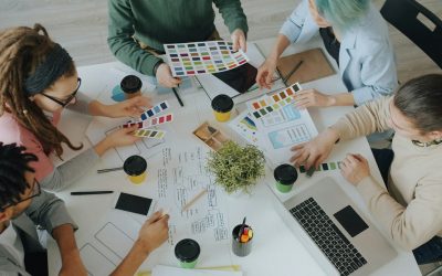 Photo by Vitaly Gariev A group of people working together on design projects at a white table